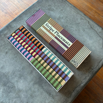 Set of striped placemats in a box on a concrete surface