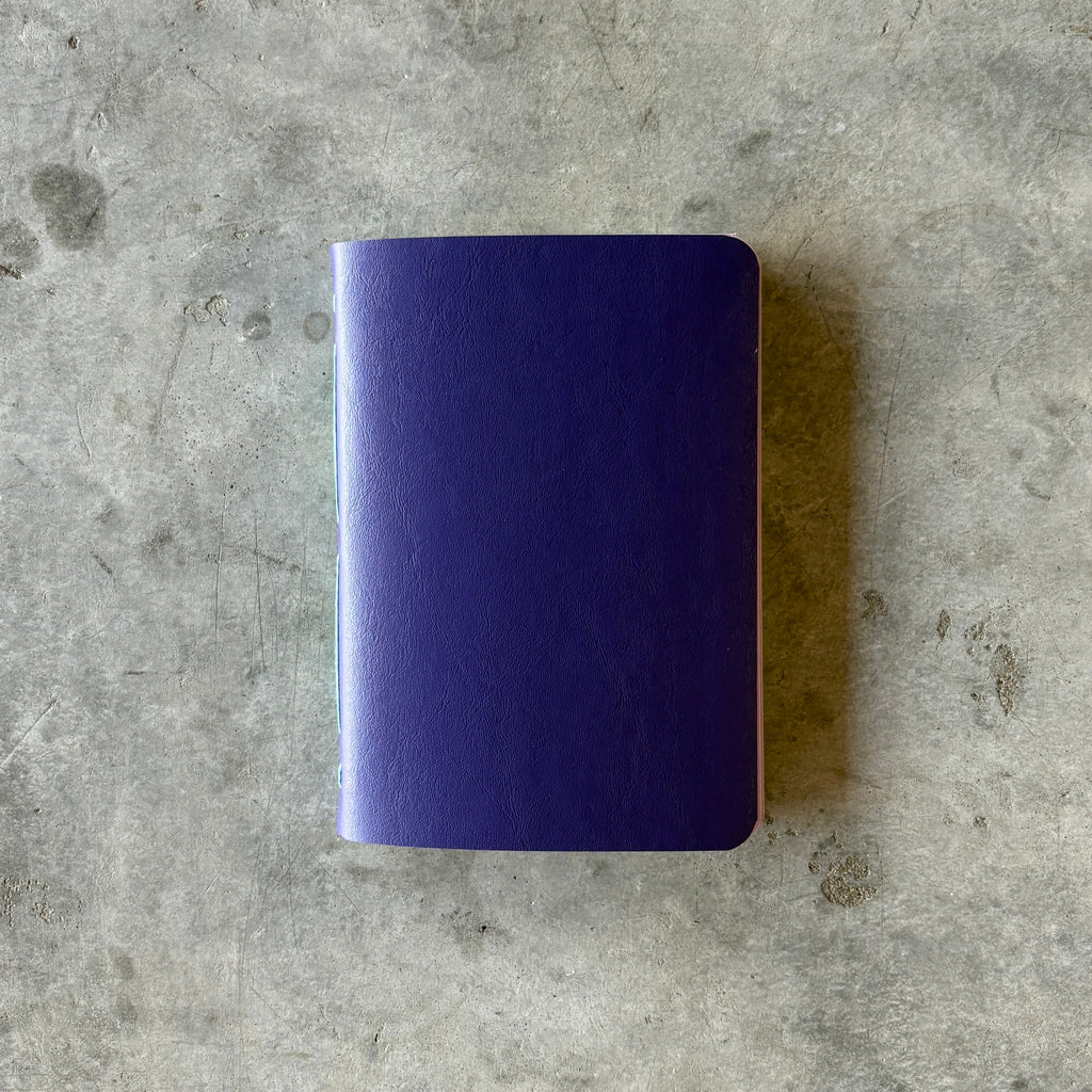 Purple notebook on a gray concrete surface