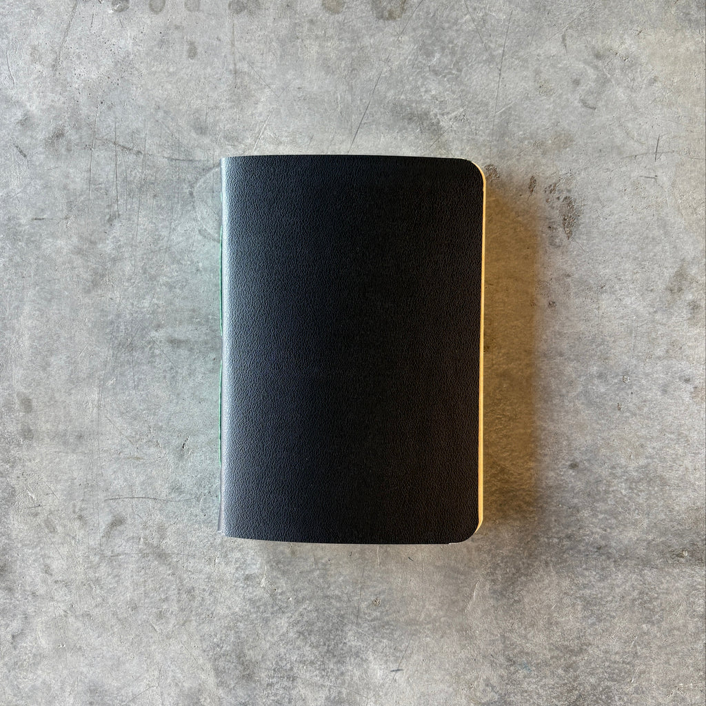 Black notebook on a textured gray surface