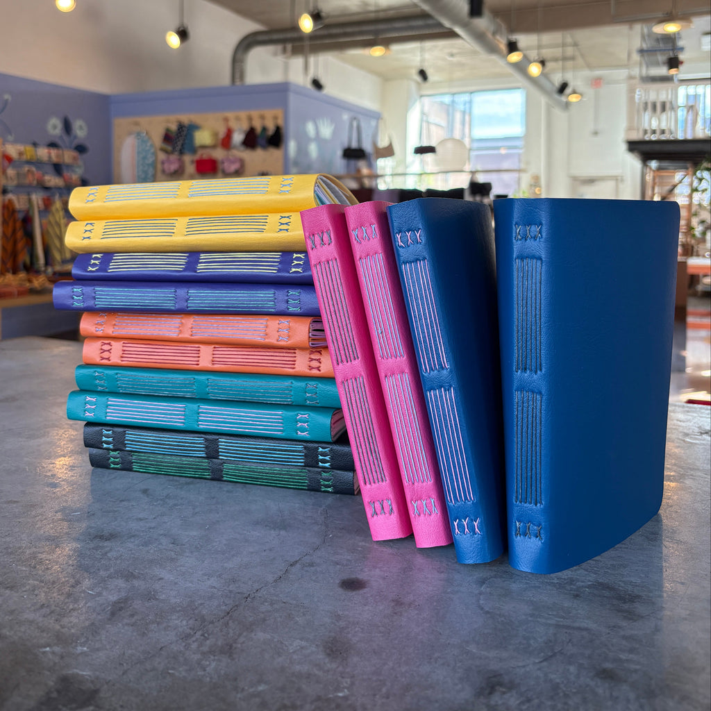 Stack of colorful books on a shelf with a store interior in the background